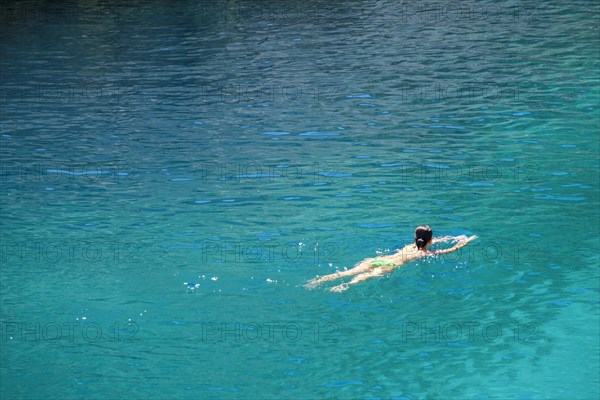 Woman swimming in the turqouise Mediterranean Sea