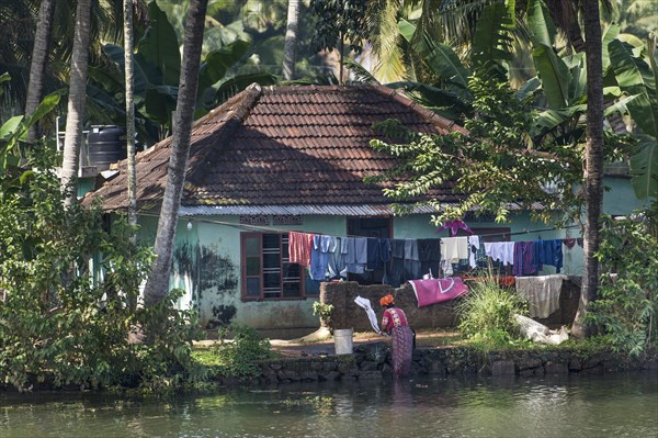 Woman washing laundry in a canal