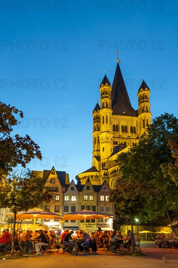 Outdoor cafes in Fischmarkt square with Great St. Martin Church in the evening