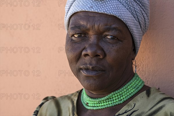 Namibian woman wearing a headscarf and green necklace