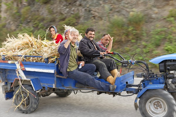 Farmers travelling on a tractor