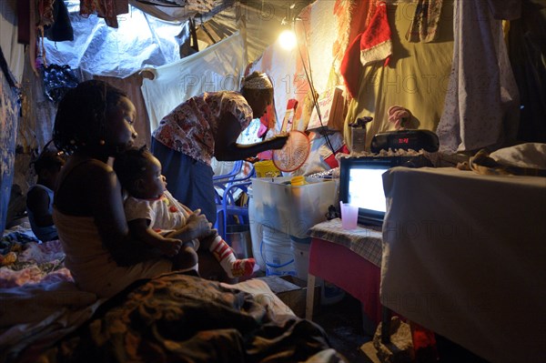 Woman and children in a ramshackle hut