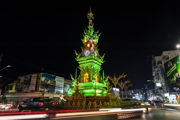 Colourfully illuminated Clock Tower at night with light trails of vehicles