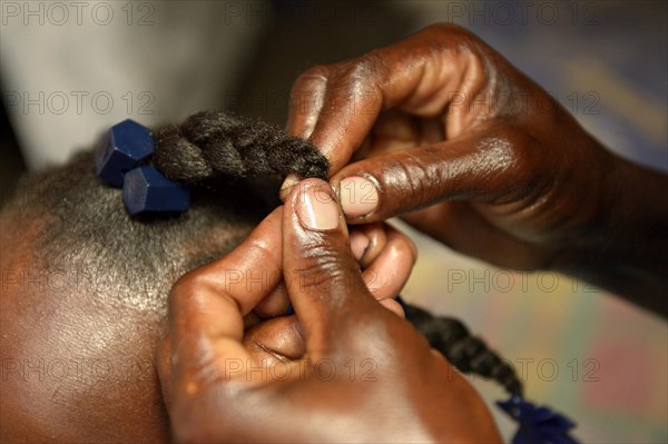 Mother braiding her daughter's hair