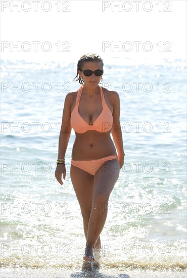 Young woman wearing a bikini coming out of the sea