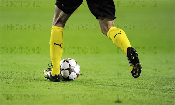 Legs of a football player from Borussia Dortmund with the official UEFA Champions League football ""Adidas Finale""