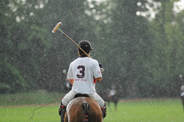 Polo players in the rain