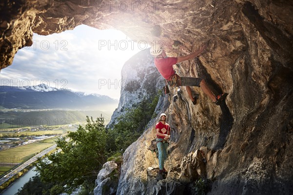 Freeclimber with helmet climbing on a rock face