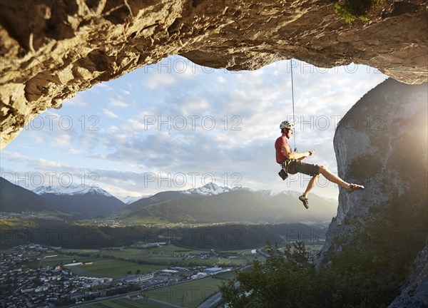 Freeclimber with helmet sits in the rope