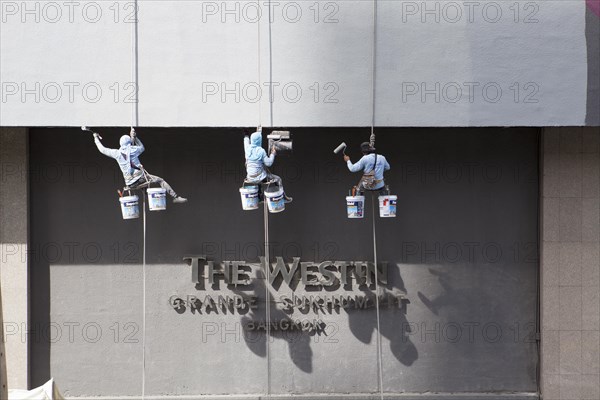 Decorators painting the facade of a high-rise building