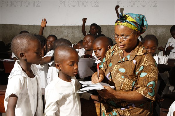Teacher and school children in school uniform during class