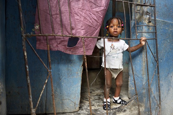 Girl behind a fence in a doorway