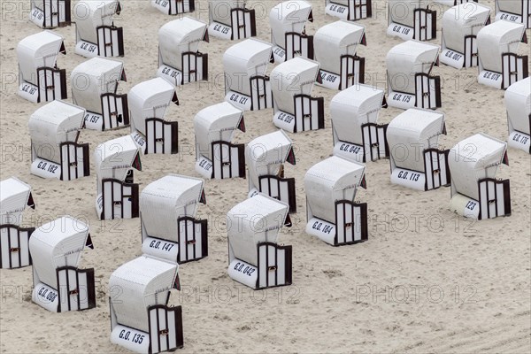 Roofed wicker beach chairs on the beach