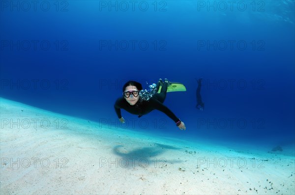 Freediver above sandy bottom