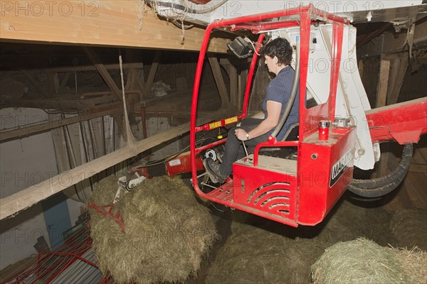 Young farmer using a hay crane