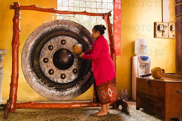 Monk using a Gong during the prayer