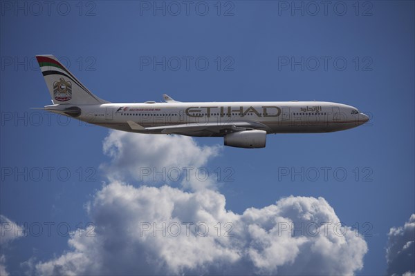 A6-EYK Etihad Airways Airbus A330-243 in flight against a cloudy sky