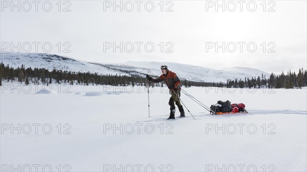 Ski tourers with Pulka in the snow