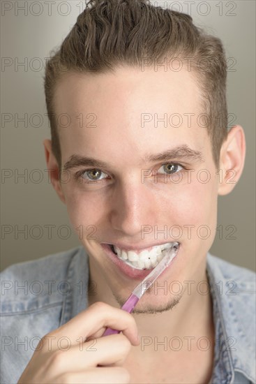 Young man brushing his teeth