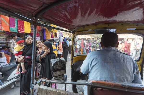 Auto-rickshaw rides through busy street