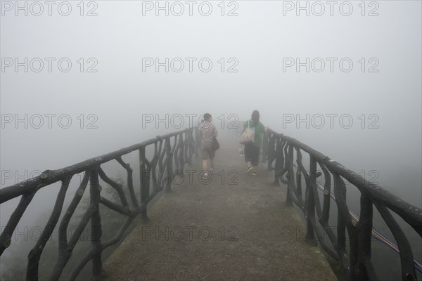 Two women on hiking trail in the fog