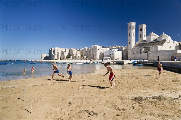 Teenagers playing football onthe beach