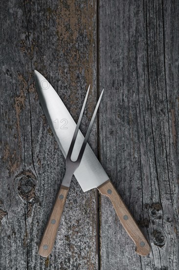 Carving knife and fork on a rustic wooden boards