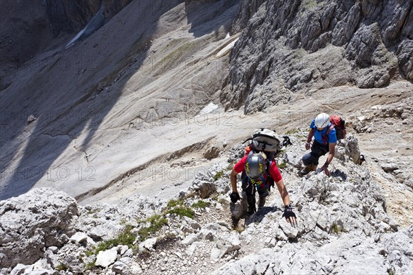 Hikers climbing to the summit of Plattkofel mountain
