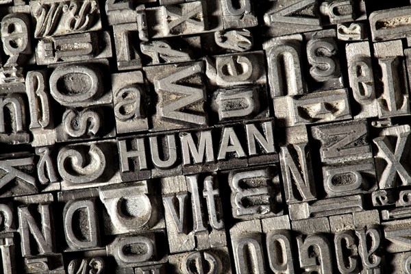 Old lead letters forming the word HUMAN