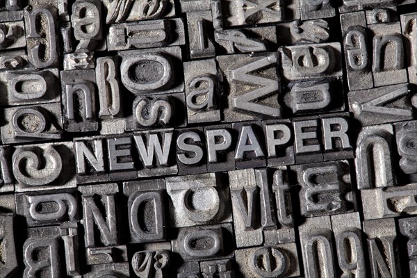 Old lead letters forming the word NEWSPAPER
