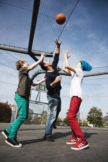 Two cool boys playing basketball with their father