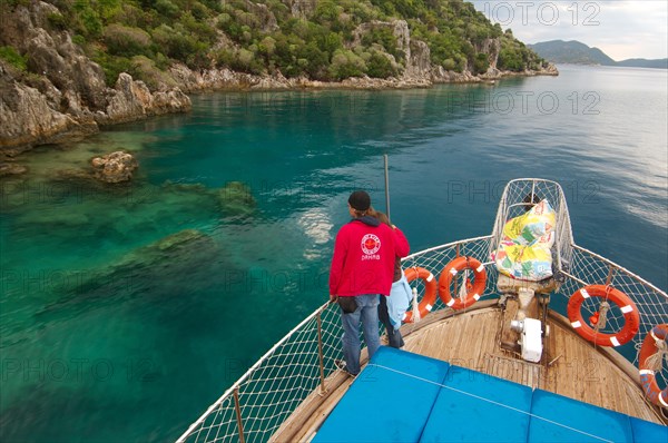 Tourists on yacht looking at the ruins of the sunken city of Kekova