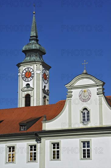 Church steeple with a tower clock and a sundial