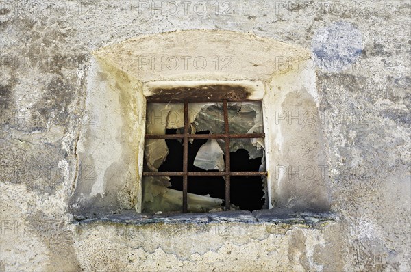 Old broken window with iron bars