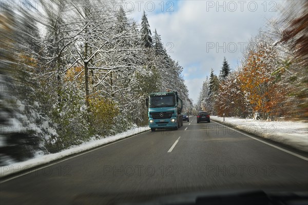A country road through a snowy forest near Feldkirchen-Westerham