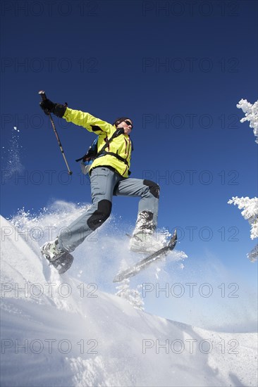 Snowshoe hiker jumping