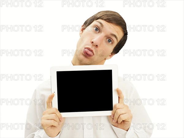 Cheeky man sticking out his tongue holding an iPad