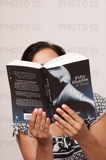 Woman reading the erotic novel Fifty Shades of Grey