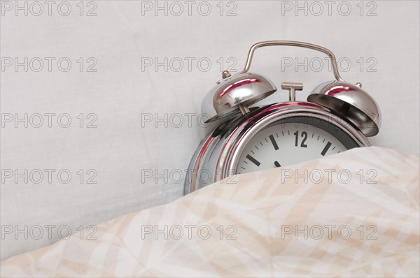 Alarm clock lying in a bed