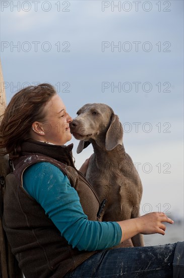 Woman with a Weimaraner on the beach