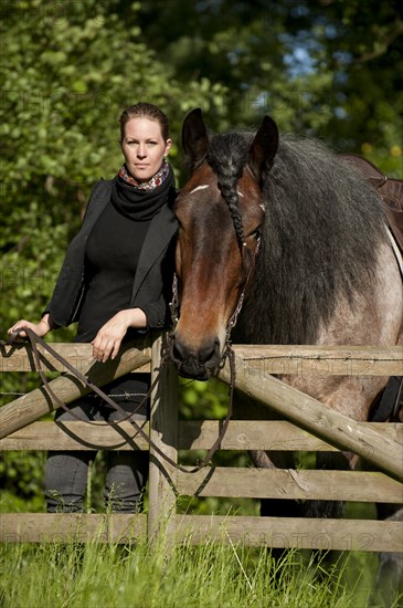 Woman with a Belgian Draft Horse at a fence