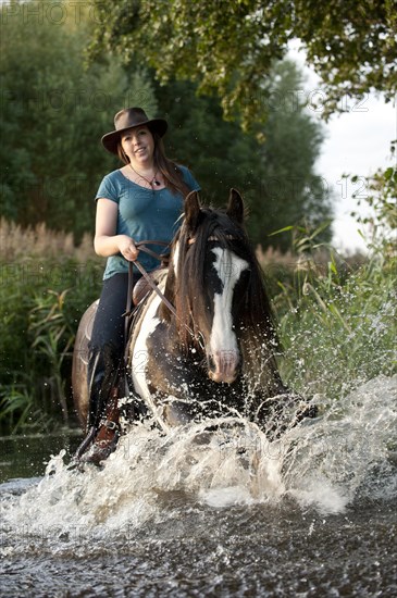 Woman riding on Irish Tinker through water