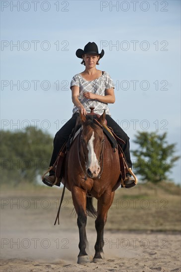 Woman riding a trotting Quarter Horse