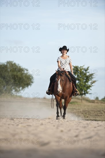 Woman riding a trotting Quarter Horse