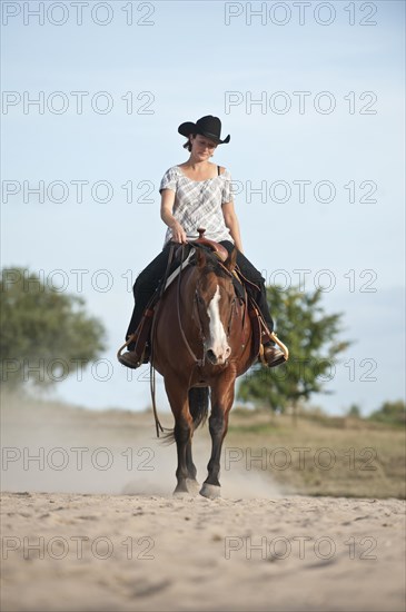 Woman riding a trotting Quarter Horse