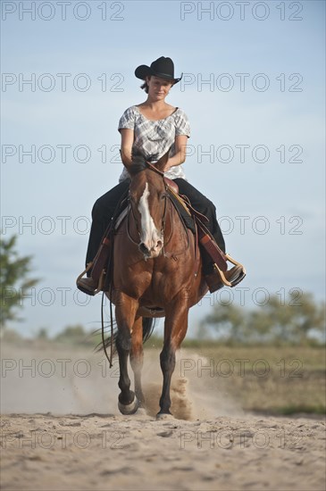 Woman riding a trotting Quarter Horse