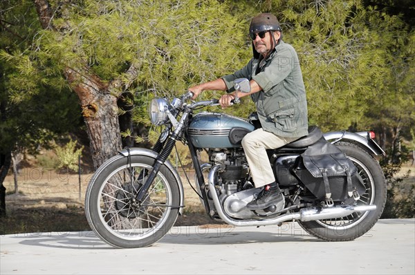 Elderly man riding a Triumph Tiger 500cc motorbike