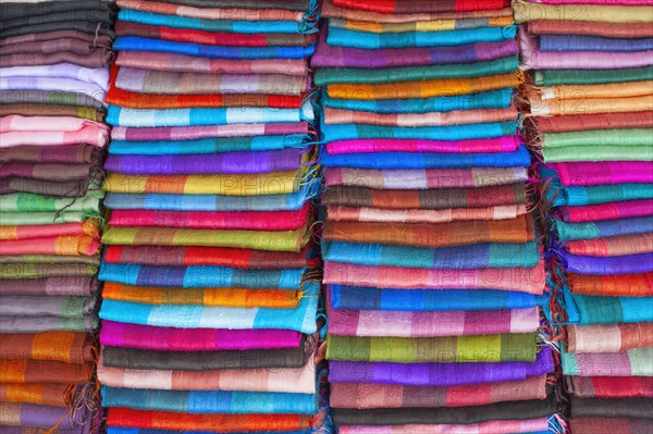 Colourful silk textiles on display at a market stall in Luang Prabang