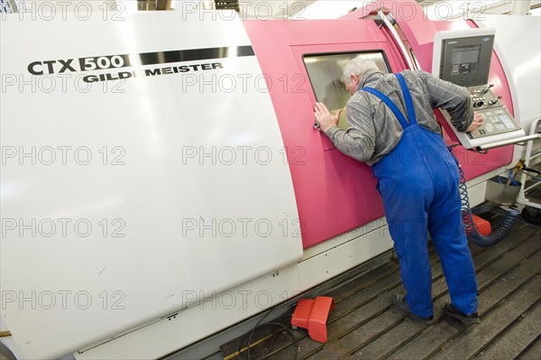 Lathe operator using a CNC Gildemeister turning lathe