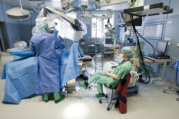 Anaesthetist monitoring a spinal surgery with a neurosurgeon in an operating room